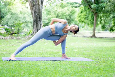 Full length of woman with arms raised on grass