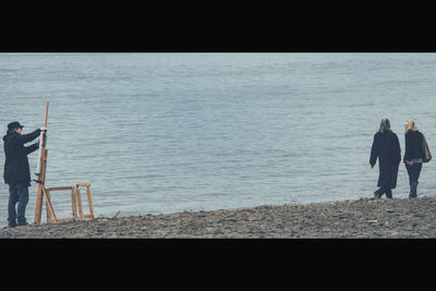 Man standing on beach against sky