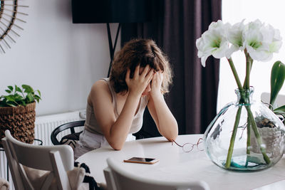 Woman sitting in vase on table