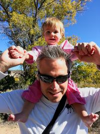 Mature man carrying girl on shoulder