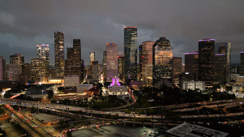 Illuminated cityscape against sky at night