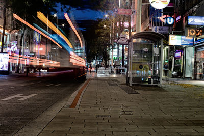 Cars on illuminated street against sky in city at night