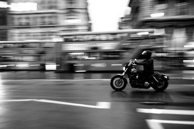 Blurred motion of man riding motorcycle on road