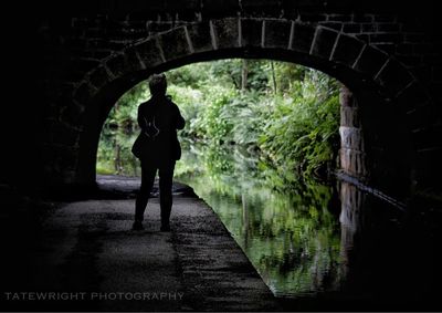 Rear view of people standing on footbridge