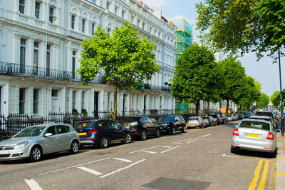 Cars on road by buildings in city