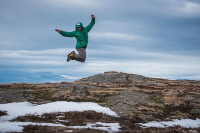 Man jumping in mid-air against sky