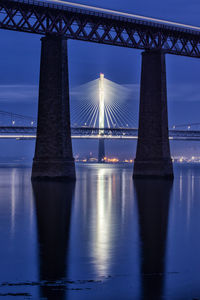 View of bridge over river at night