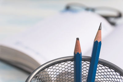 High angle view of pencils on metal fence