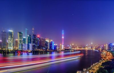 Light trails on huangpu river by cityscape at night