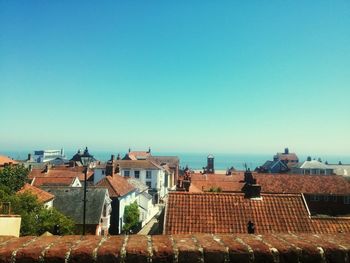 Houses in town against clear blue sky