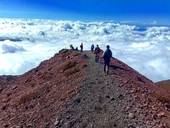 People on mountain against sky