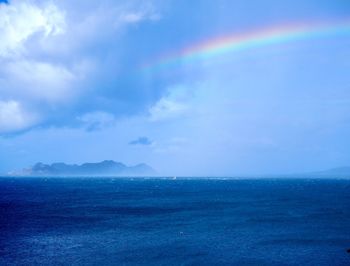 Scenic view of rainbow over sea against sky