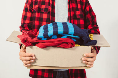 Midsection of woman holding gift against white background