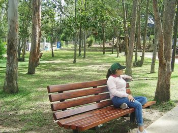 Woman sitting on bench in park