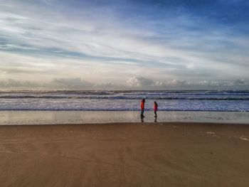 People on beach against sky