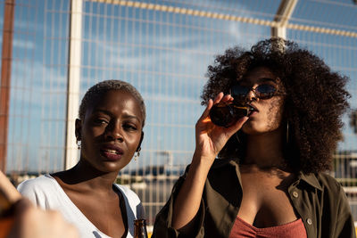 Cheerful young diverse female friends celebrating meeting in city