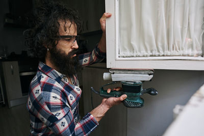 A young men using a sander. concept mens work