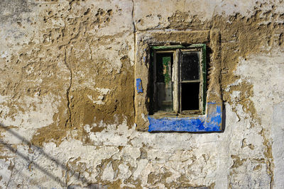 Low angle view of window on wall of old building