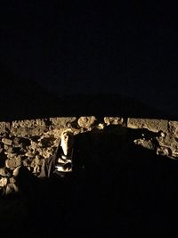 Boy sitting on floor at night