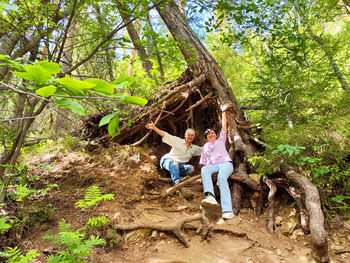 Side view of woman sitting on rock