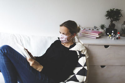 Young woman sitting on bed at home