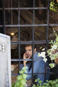 High angle view of man looking away while sitting at cafe