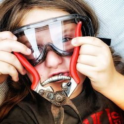 Close-up portrait of boy wearing protective eyewear while holding pruning shears