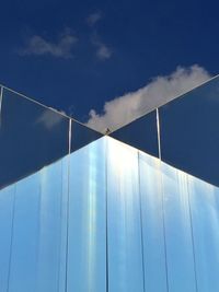 Low angle view of modern building against blue sky