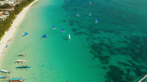 Tropical lagoon with turquoise water, sailing yachts and white sand beach. boracay, philippines. 