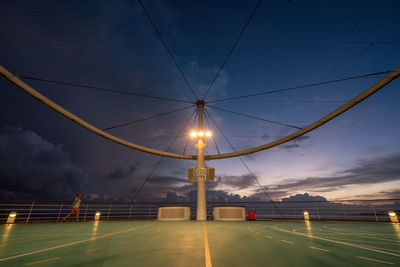 Mid distance view of woman on ship against sky during dusk