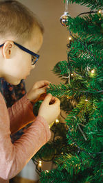 Close-up of boy decorating christmas tree
