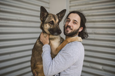 Portrait of young man holding dog