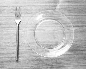 Directly above shot of glass plate by fork on table