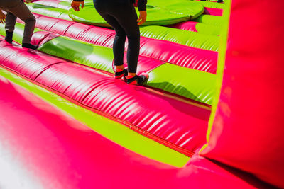 Low section of people walking on multi colored umbrella