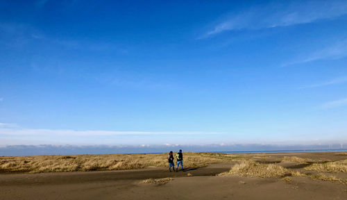 Rear view of people walking on land