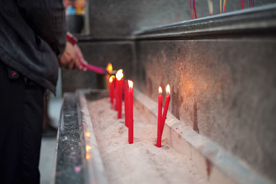 Burning candles in temple against building