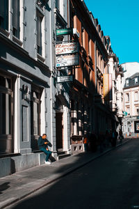 Man walking on street amidst buildings in city