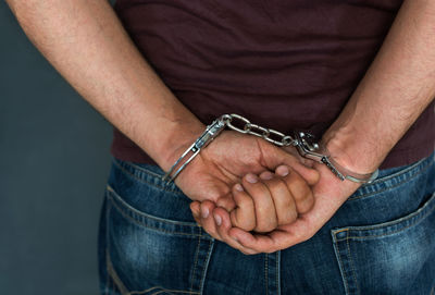 Midsection of criminal wearing handcuffs