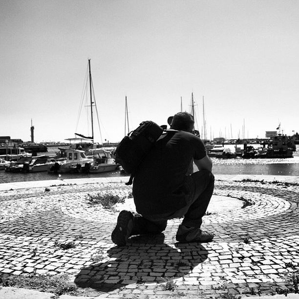 nautical vessel, water, transportation, rear view, mode of transport, lifestyles, clear sky, men, leisure activity, sea, boat, sitting, moored, full length, harbor, sky, casual clothing