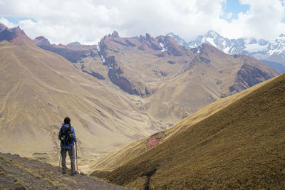 Rear view of woman standing against mountain range