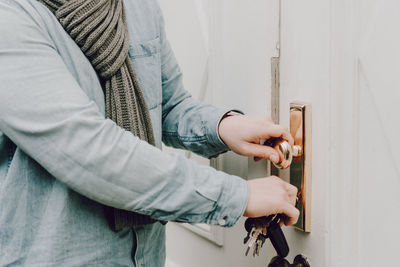 Midsection of man opening door