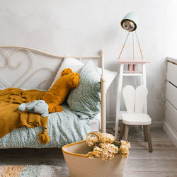 Stylish children's room of the child. wicker basket with flowers, pillows on the bed mint and brown