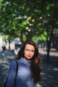 Beautiful young woman against trees