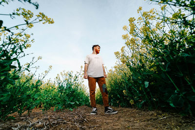 Full length of man standing by tree against sky