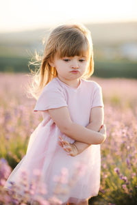 Cute girl standing on flower field
