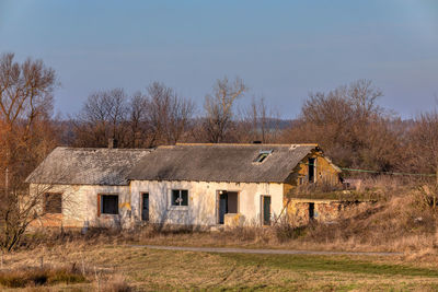 Abandoned house on field against sky