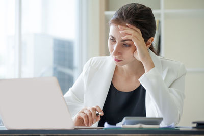 Businesswoman using laptop in office