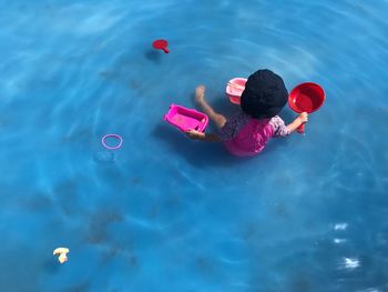 High angle view of boy with toys in swimming pool