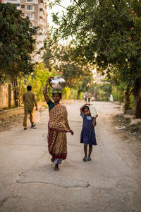 Rear view of siblings walking on tree