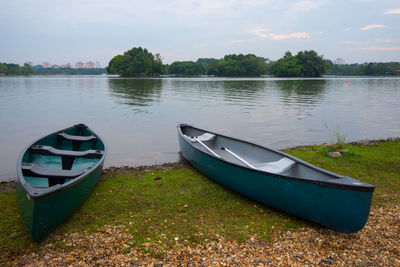 Boat moored in lake against sky